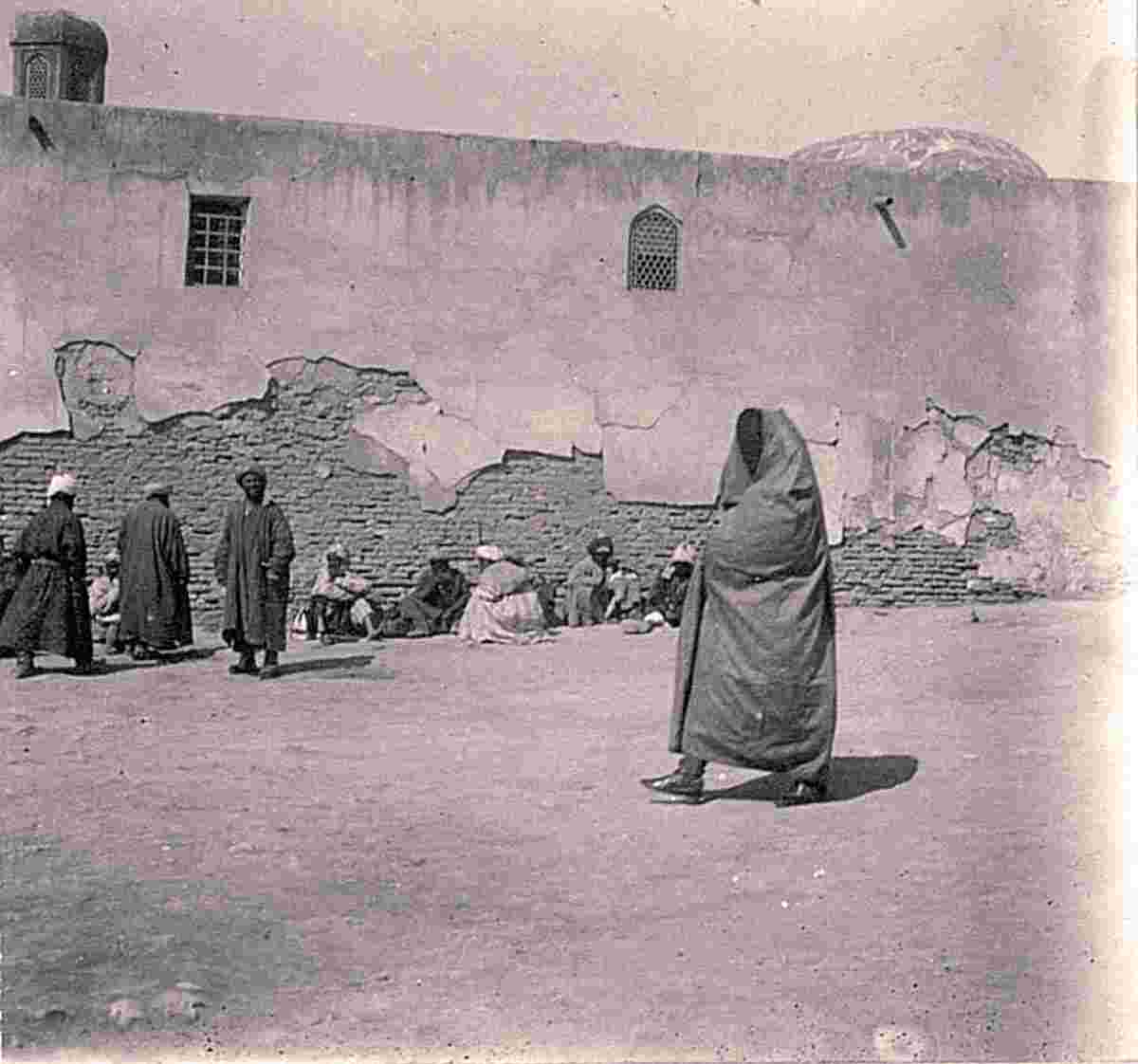 Bukhara. A woman wearing a headscarf near the wall of the Doru healing madrasa in Registan Square