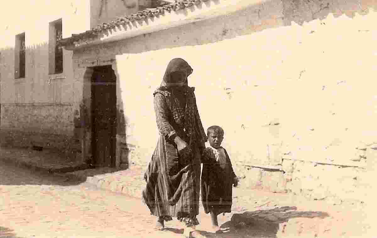 Berat. Woman with a child on a town street, 1940s